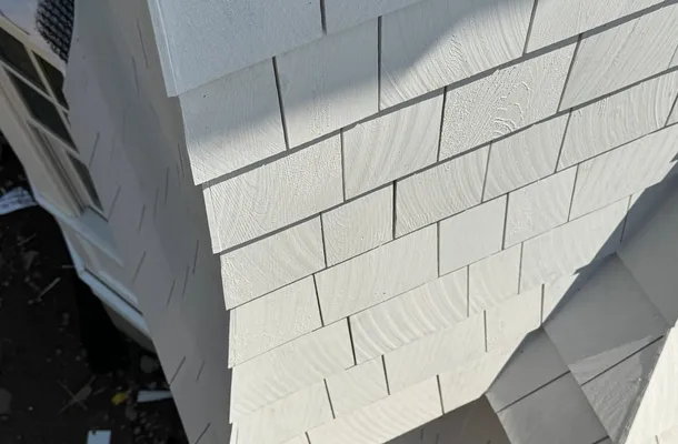 Freshly installed light-gray HardieShingle staggered shake siding by North Valley Exteriors