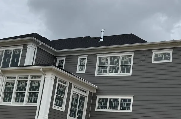 Rows of white-trimmed Andersen windows on a gray HardiePlank home by North Valley Exteriors